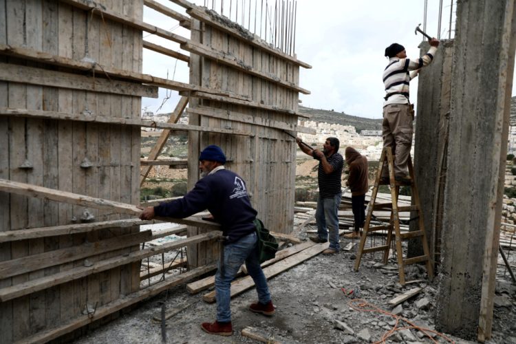 Palestinian Labourers work at a construction site in the Israeli settlement of Ramat Givat Zeev as the Palestinian Authority imposes a ban on Palestinians from working in Israeli settlements over concerns of the spread of coronavirus disease, in the Israeli-occupied West Bank March 19, 2020. REUTERS/Ammar Awad - RC20NF9K8CMF